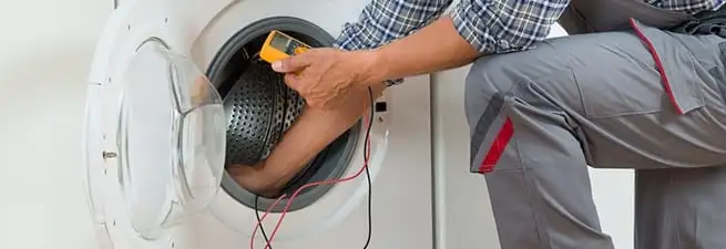 Dryer repair technician inspecting and repairing a clothes dryer in Lakeland, FL