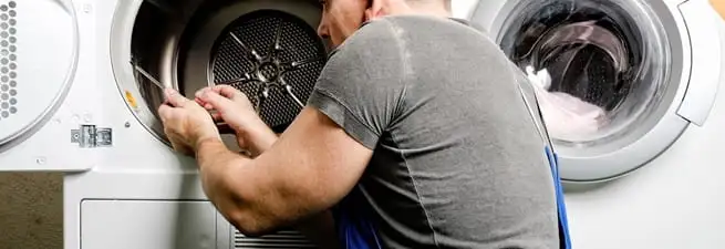 Dryer repair technician fixing a clothes dryer drum in Lakeland, FL