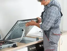 Appliance repair technician installing a built-in cooktop in Lakeland, FL
