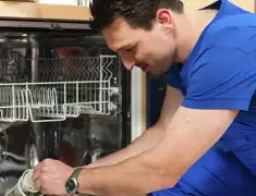 Dishwasher repair technician inspecting and servicing an open dishwasher in Lakeland, FL
