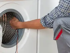 Dryer repair technician diagnosing and servicing a clothes dryer in Lakeland, FL