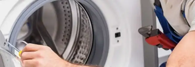 Appliance technician repairing a clothes dryer drum and internal parts in Lakeland, FL