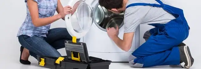 Washer repair technician inspecting a front-load washing machine with tools in Lakeland, FL