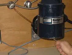 Garbage disposal repair technician tightening the mounting ring under a sink in Lakeland, FL