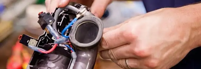 Vacuum repair technician reconnecting wiring and components in Lakeland, FL