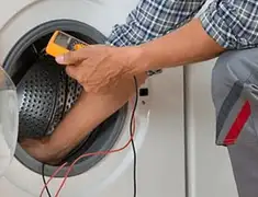 Washing machine repair technician testing a front-load washer with diagnostic tools in Lakeland, FL