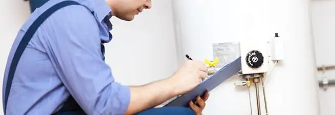 Water heater repair technician inspecting the unit and recording service notes in Lakeland, FL