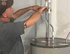 Water heater repair technician tightening supply line connections in Lakeland, FL