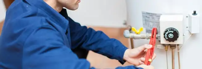 Water heater repair technician adjusting the temperature control and gas valve in Lakeland, FL